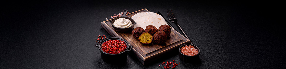 foto de una charola con piezas de falafel, tortillas y salsa árabe de yogur.